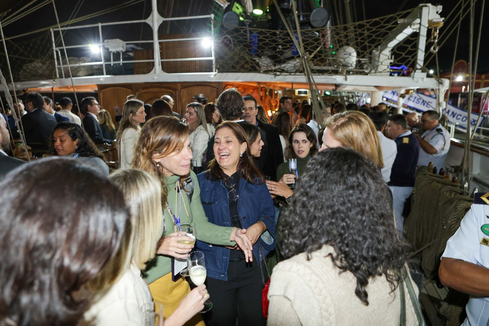 Convidados em happy hour a bordo do Cisne Branco à noite