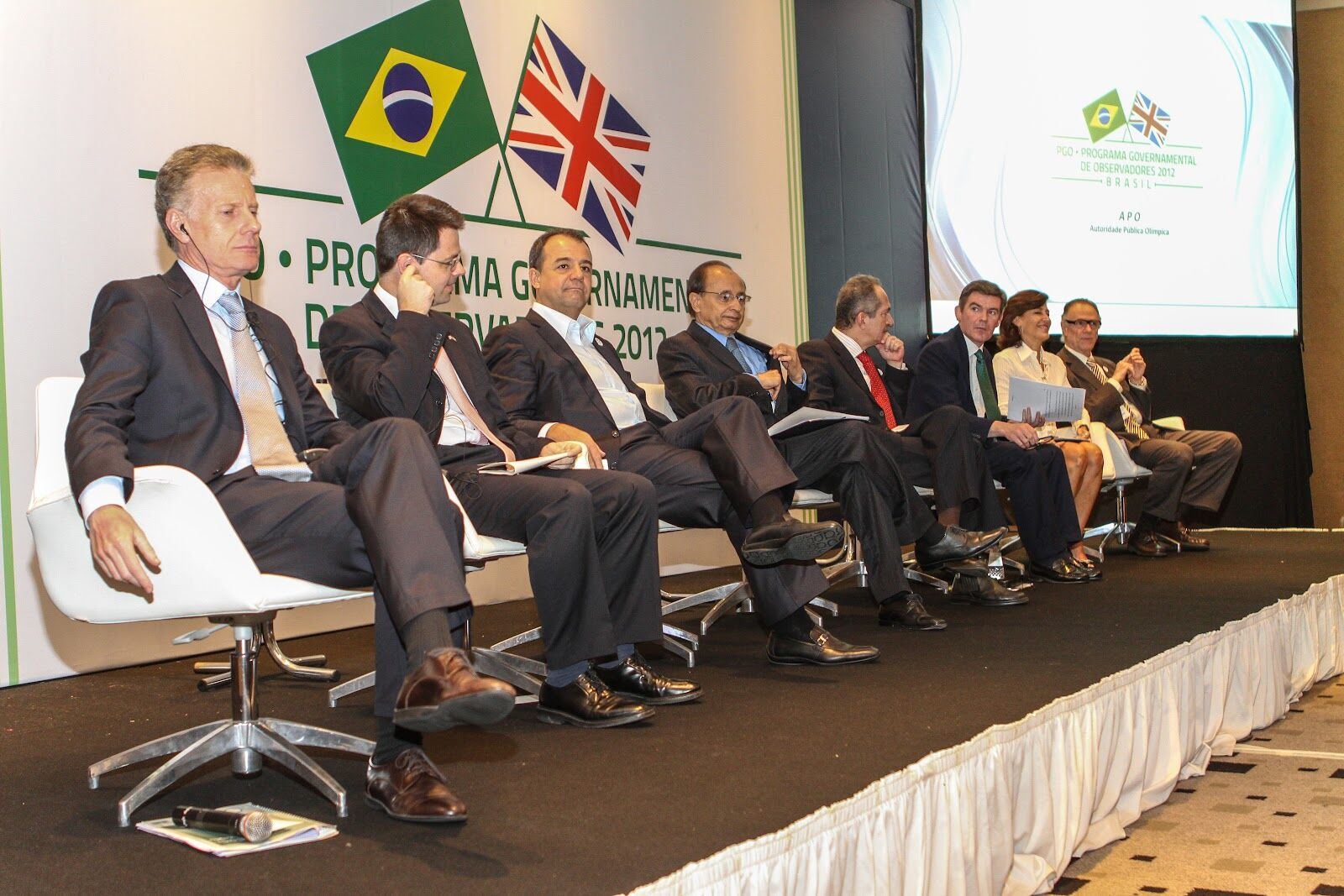 Seminário internacional em Londres com bandeiras do Brasil e do Reino Unido